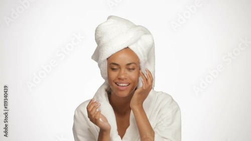 african american woman applying cream on her face
