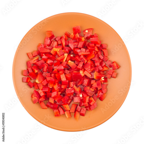 Sliced red pepper in a brown ceramic plate. Isolated on white ba