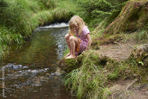 Fototapeta Naklejka Na Ścianę i Meble -  Child cute blond girl playing in the creek. Summer children fun.

