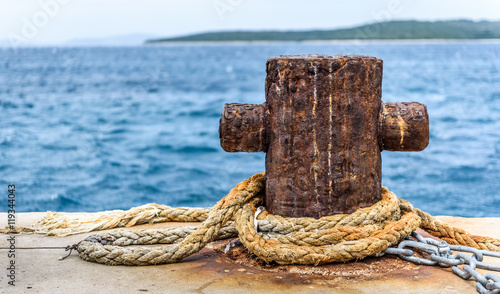 Photography Old rusty steel mooring bollard pole on a pier.