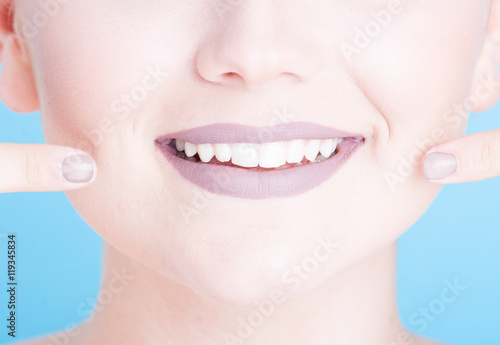 Close-up girl pointing her beautiful smile with lipstick