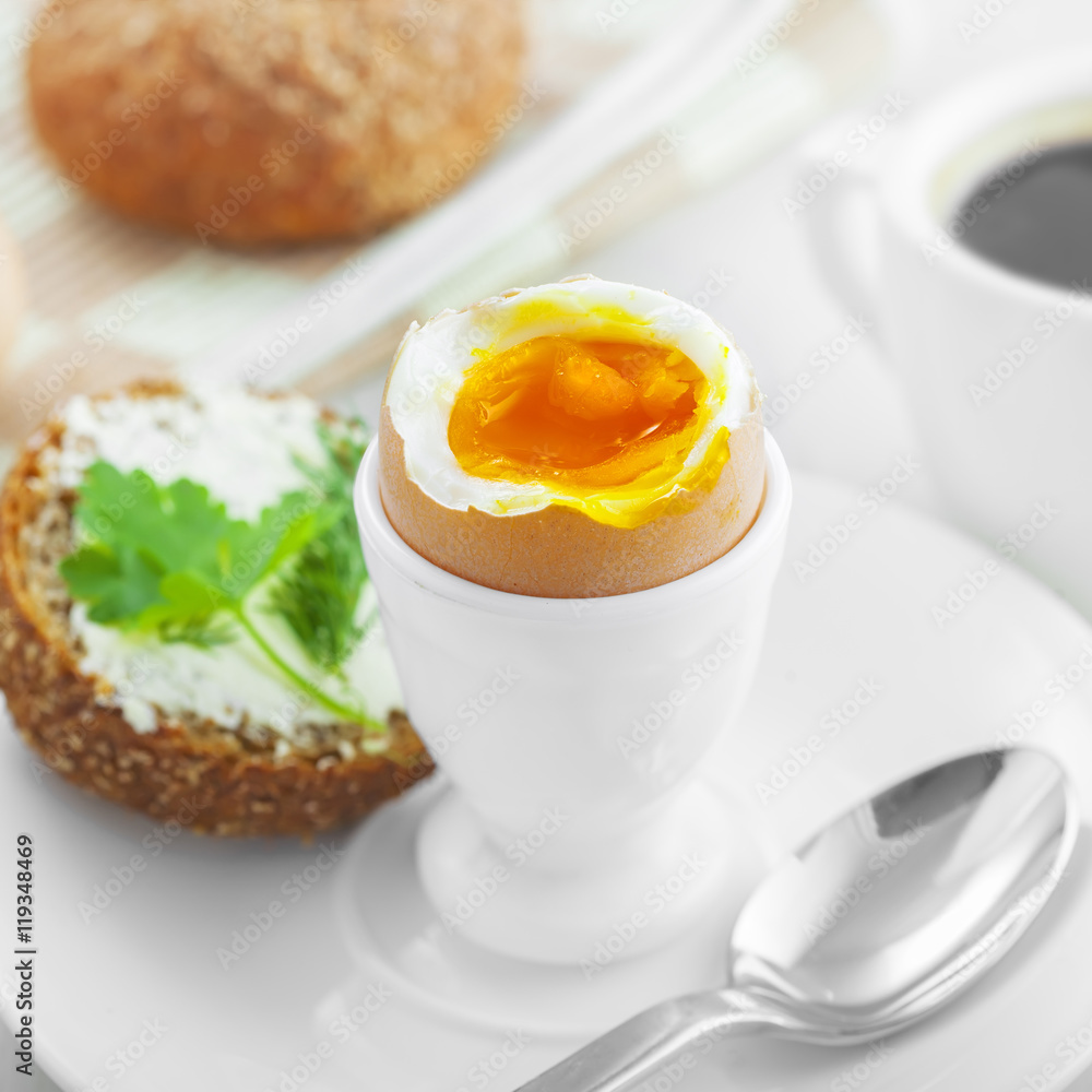 Perfect soft boiled egg, open bread sandwich with butter and cup of coffee on a table. Traditional food for healthy breakfast. Perfect soft boiled egg, open bread sandwich with butter and cup of coffee on a table. Traditional food for healthy breakfast.