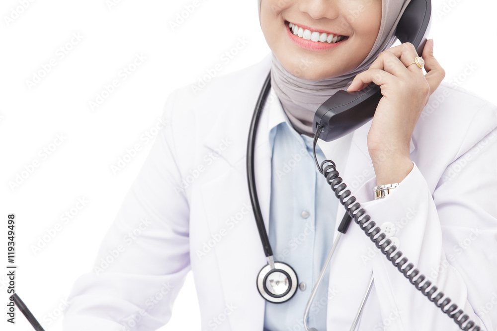 asian female doctor with stethoscope talking on the phone while asian female doctor with stethoscope talking on the phone while