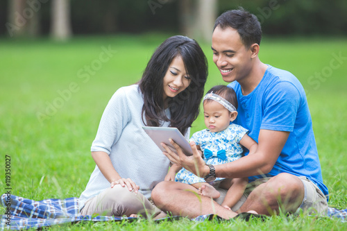 Baby in the park using tablet pc © Odua Images