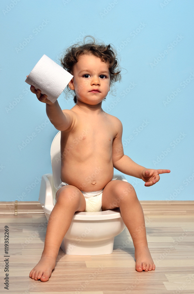Baby toddler sitting on the potty and playing with toilet paper. Cute kid potty  training for pee and poo Stock Photo | Adobe Stock