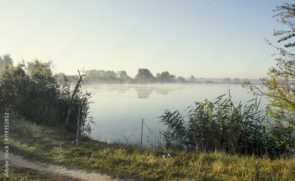 Fototapeta premium Misty sunrise over a lake summer morning