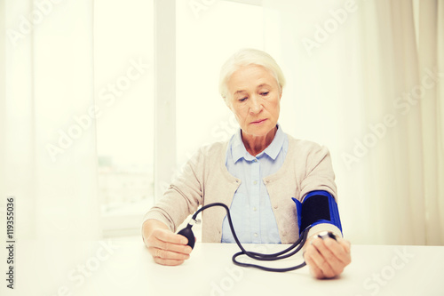 old woman with tonometer checking blood pressure