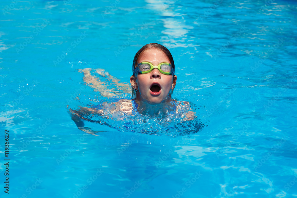 Child swims butterfly style in the pool