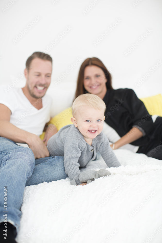 Happy parents playing with son on bed Happy parents playing with son on bed