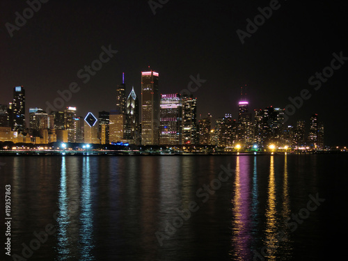 Chicago skyline at night across water with reflections