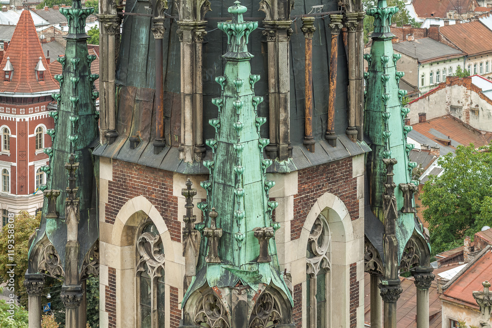 Naklejka premium Detail of the tower of the Church of Saints Olga and Elizabeth on a background of Lviv roof
