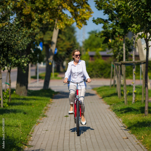 Fototapeta Naklejka Na Ścianę i Meble -  Urban biking - woman riding bike in city park 