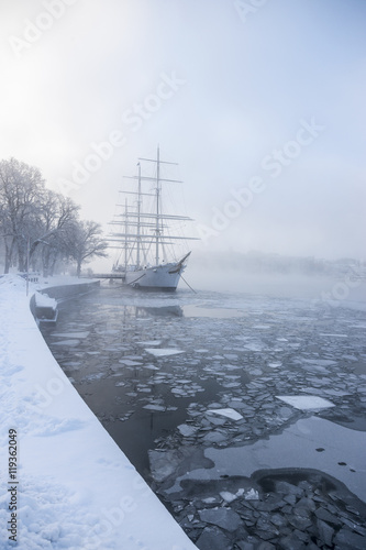 Sailing boat on frozen water, Skeppsbron, Stockholm, Sweden photo