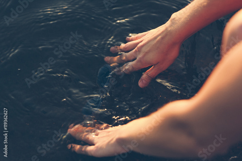 Hands washing diving goggles in water, Sweden