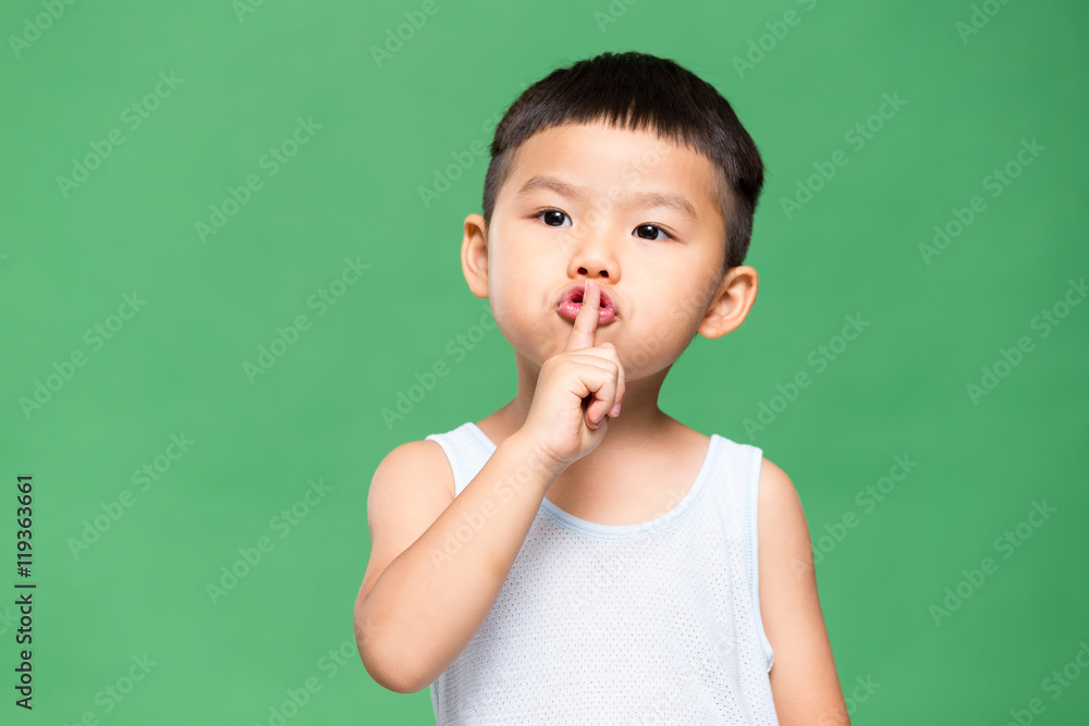 Little kid putting a finger on his lips Little kid putting a finger on his lips