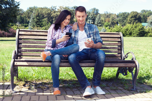 Young couple amazed watching smart phone outdoor