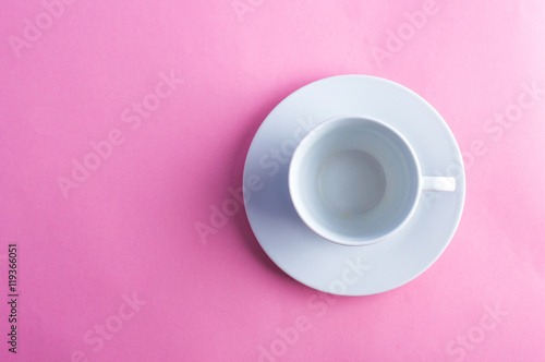White cup and saucer on a colored background. Flat lay.
