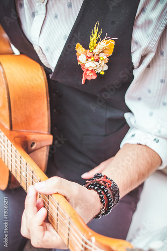 close up finger of guitarist while playing guitar in the outdoor garden