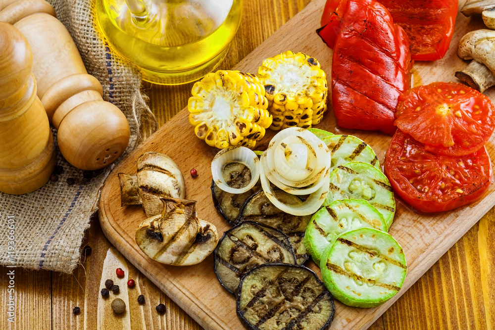 Vegetables roasted on a grill: tomato, corn, eggplant, mushroom, bell pepper, marrow and onion. Delicious healthy food for lunch. Close-up shot. Vegetables roasted on a grill: tomato, corn, eggplant, mushroom, bell pepper, marrow and onion. Delicious healthy food for lunch. Close-up shot.