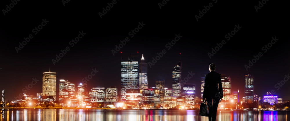 Naklejka premium Businesswoman viewing night glowing city