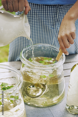 Woman preparing lemonade in jar