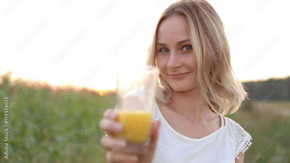Healthy woman drinking orange juice and smiling Healthy woman drinking orange juice and smiling