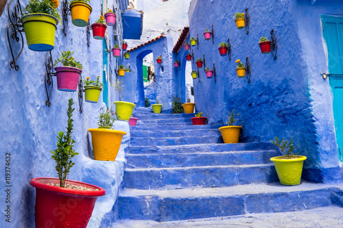 Morocco, Chefchaouen or Chaouen  is most  noted for its small narrow streets and neighborhoods painted in  variety of vivid blue colors. Plantings in colorful pots line the narrow corridors. photo