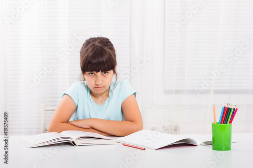 Angry little girl must stay at home and do her homework,but she would rather play outside.