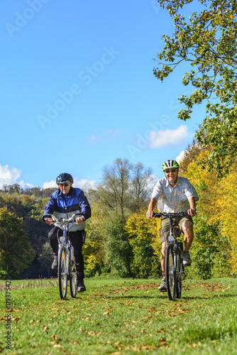 rüstige Senioren machen eine Radtour in herbstlicher Natur