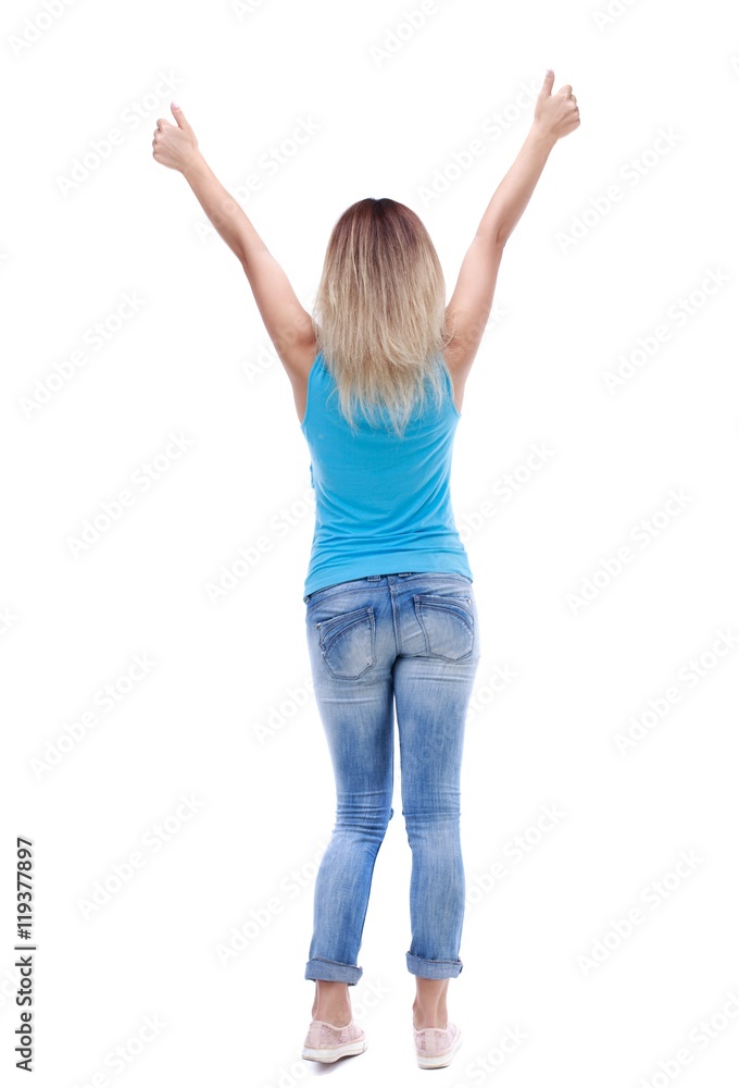 Back view of woman thumbs up. Rear view people collection. blonde in a blue shirt and jeans showing thumbs up with both hands. Back view of woman thumbs up. Rear view people collection. blonde in a blue shirt and jeans showing thumbs up with both hands.
