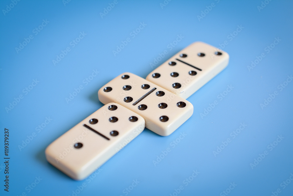Domino parts, only showing number five over blue table Domino parts, only showing number five over blue table
