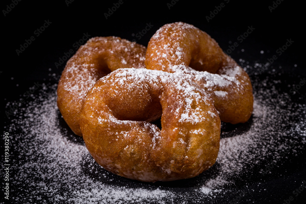 Sprinkling sugar powder on donut