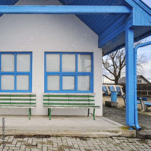 Wartehaus mit Bank in gruenweiß und blauen fenstern photo