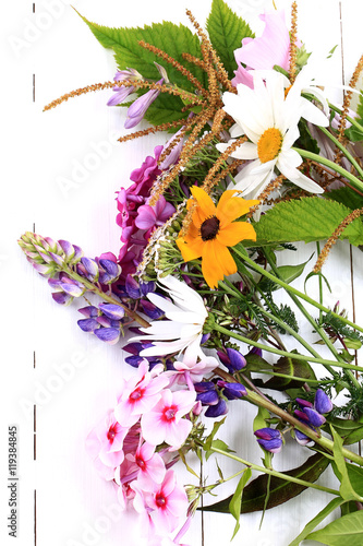 garden flowers on white wooden background view from above a flat appearance