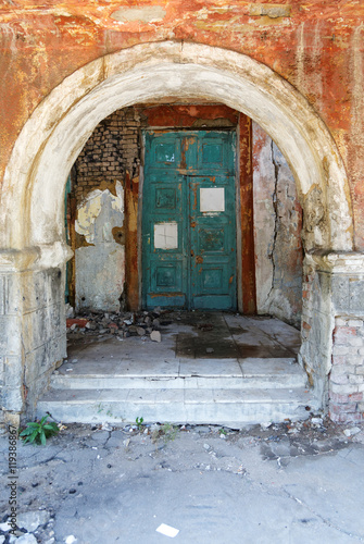 old door and the arch in the crumbling building © sergey makarenko