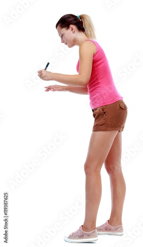 back view of writing beautiful woman. Isolated over white background. Sport blond in brown shorts writes marker.