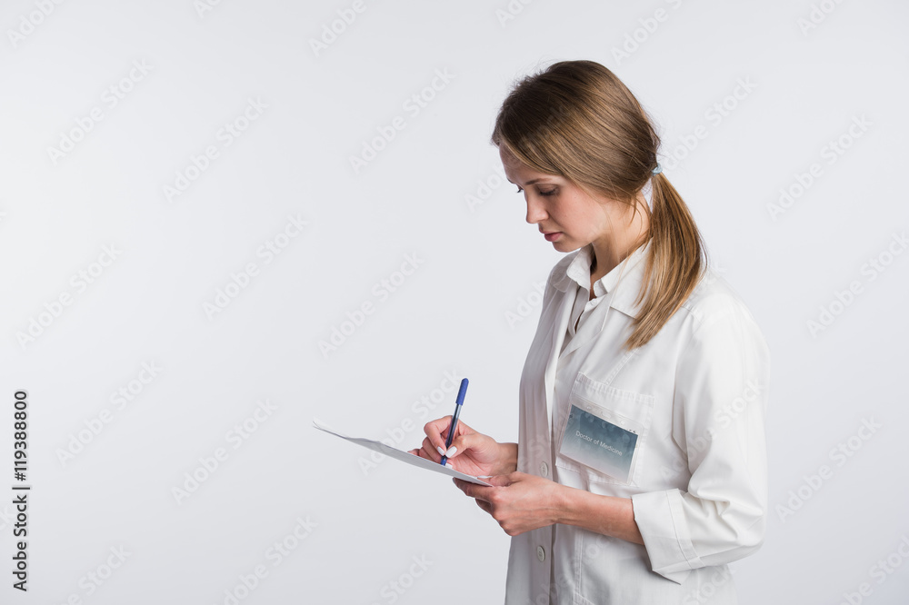 Cheerful medical doctor woman taking notes. Isolated on white Cheerful medical doctor woman taking notes. Isolated on white