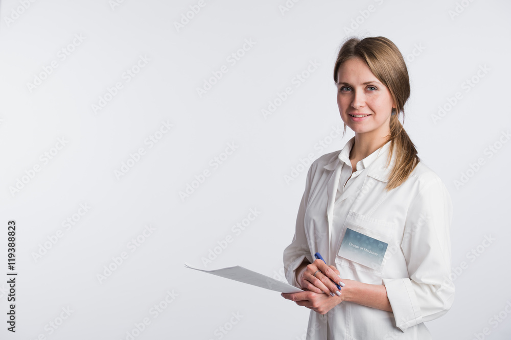 Beautiful nurse smiling and taking notes on a white isolated background Beautiful nurse smiling and taking notes on a white isolated background