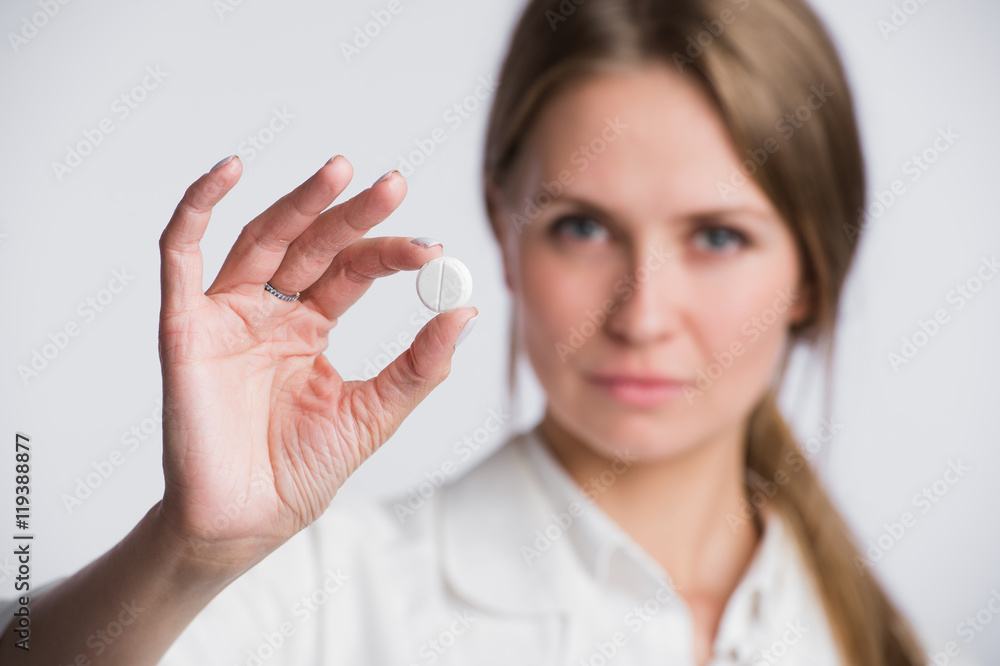 Serious medical woman with pill. Young beautiful nurse holding medicament on white. Serious medical woman with pill. Young beautiful nurse holding medicament on white.