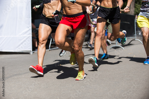 Running people on crossfit competition, feet on the road close up photo