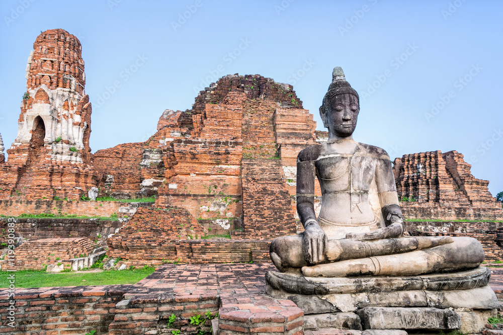 Ancient ruins of pagoda and old buddha statue at Wat Phra Mahathat temple is a famous attractions in Phra Nakhon Si Ayutthaya Historical Park, Thailand