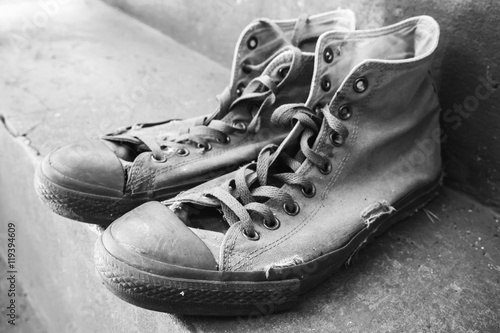 Tableau sur toile Pair of old sneakers standing on concrete stairs