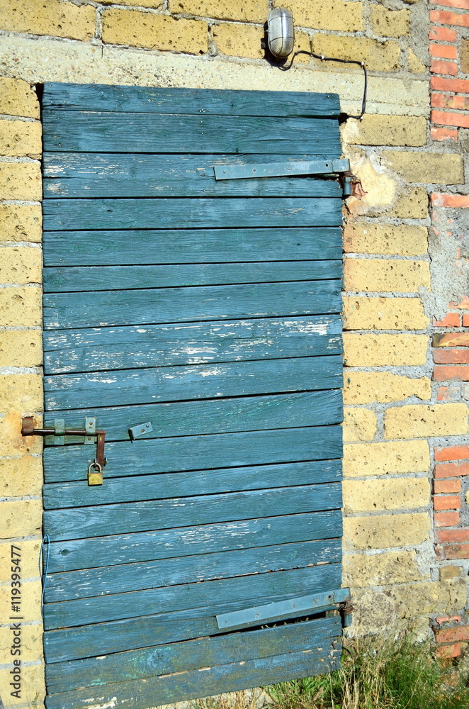 Naklejka premium Blaue Holztür in Steinhaus