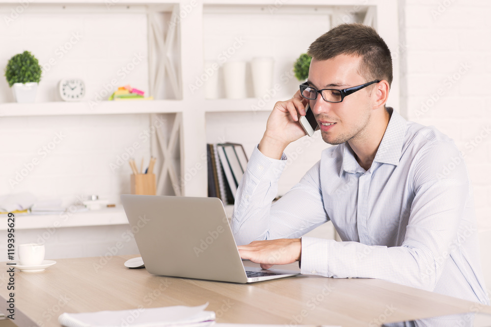 Man on phone using laptop Man on phone using laptop