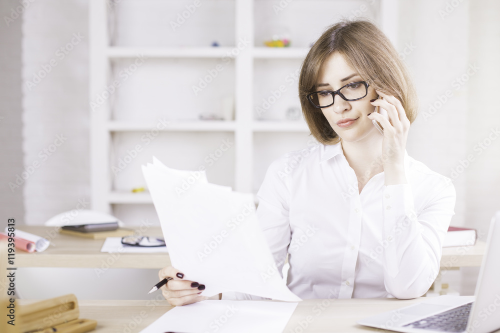 Woman on phone doing paperwork Woman on phone doing paperwork
