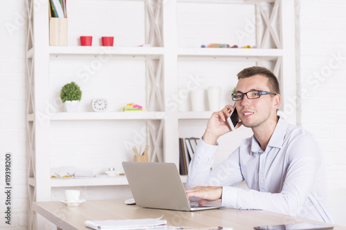 Wallpaper Mural Businessperson on phone using laptop Torontodigital.ca
