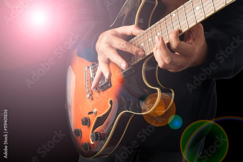 A man is playing guitar with lighting effect.