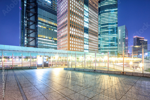 Canvas Print modern buildings in tokyo at night from empty footpath