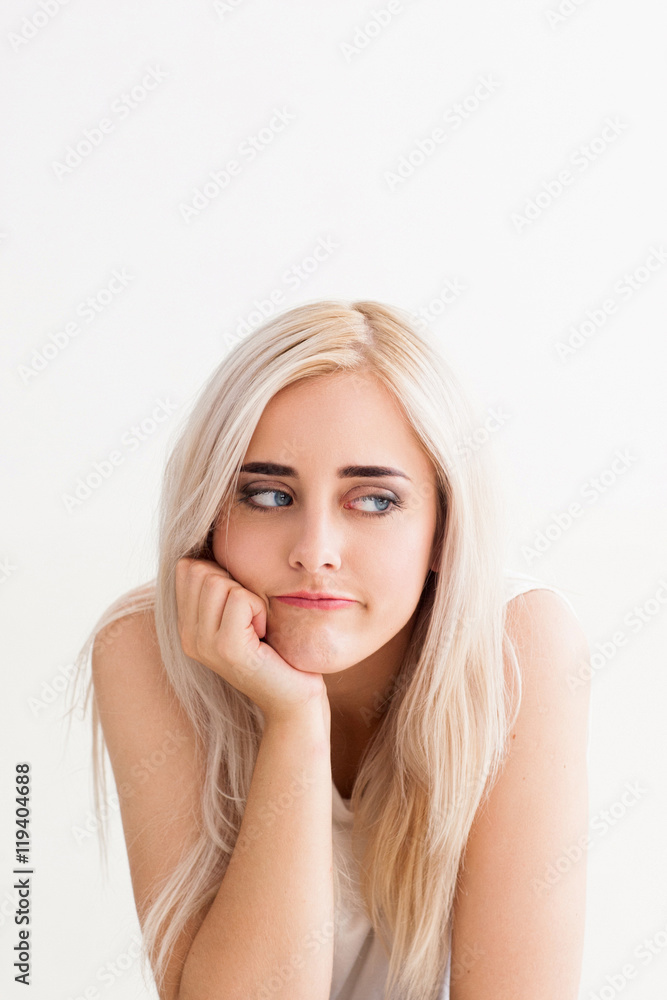 Beautiful woman with boring look, copy space. Pensive attractive blonde feeling disappointment, fatigue, boredom. White background Beautiful woman with boring look, copy space. Pensive attractive blonde feeling disappointment, fatigue, boredom. White background