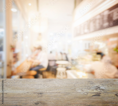 wooden table top with blur of coffee shop interior as background